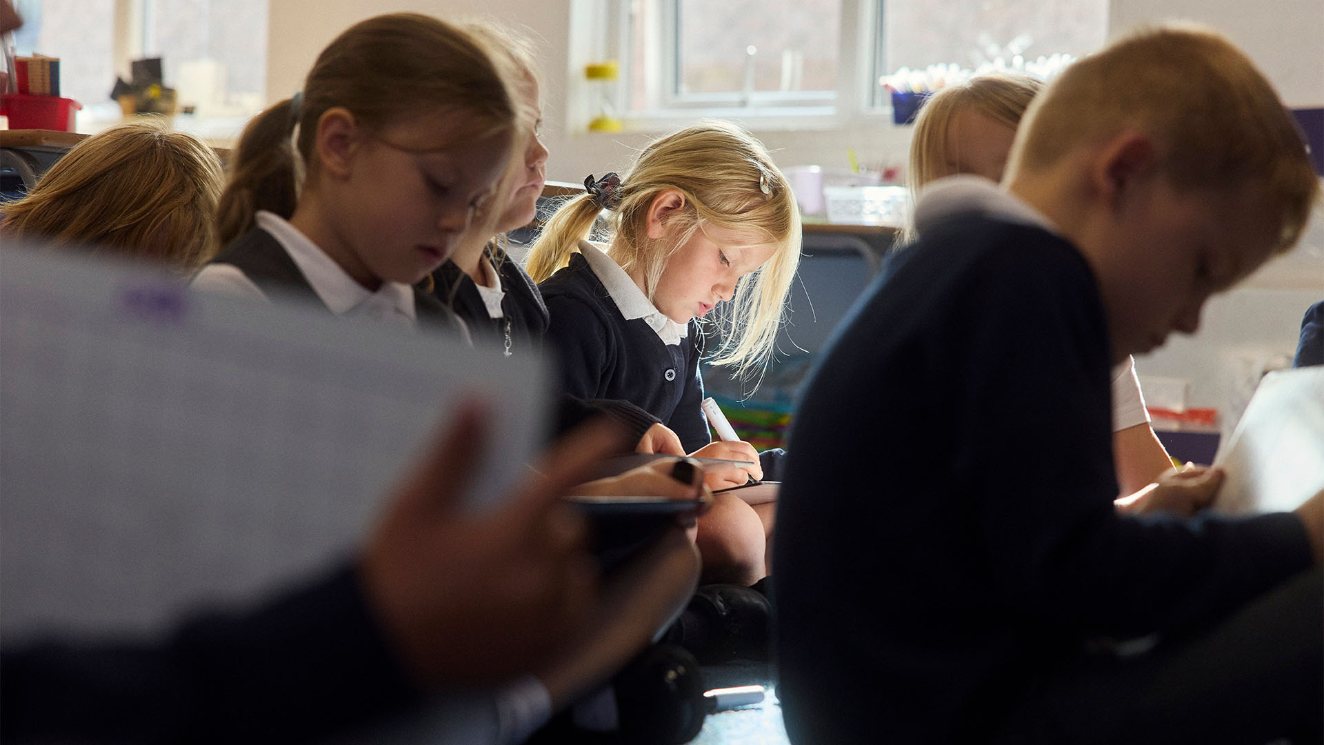 Pupils sat on carpet writing on mini whiteboards