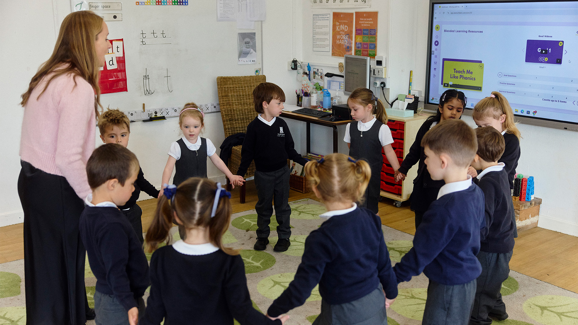 Teacher and pupils holding hands in a circle