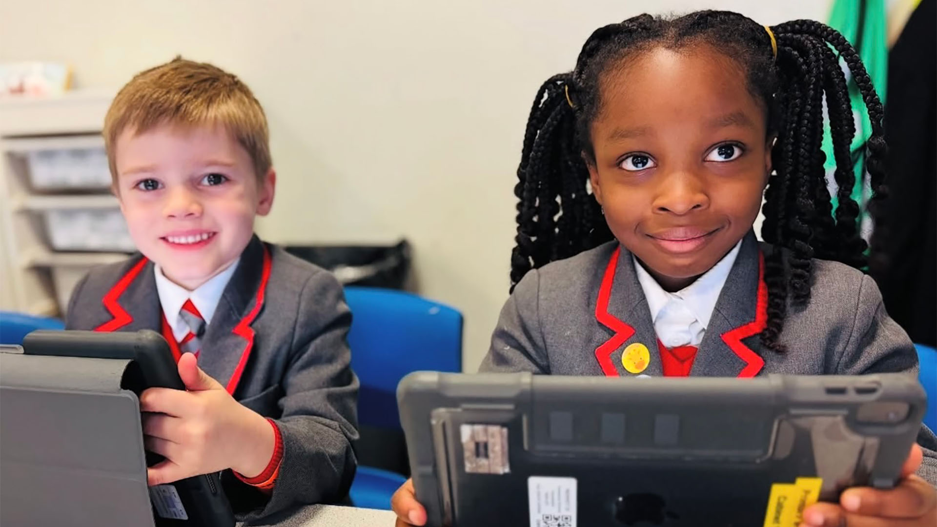 Two pupils looking up from their tablets